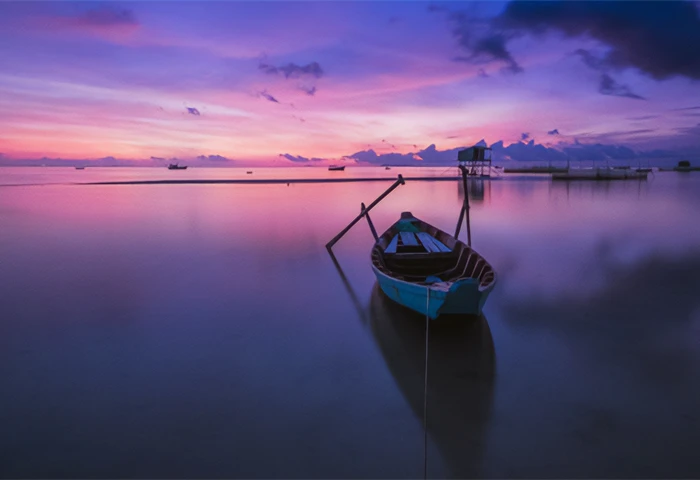 Barque sur l'eau avec un coucher de soleil